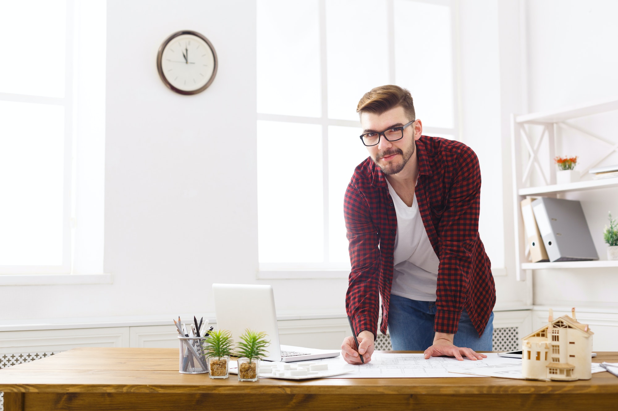 Young architect working with blueprints in the office